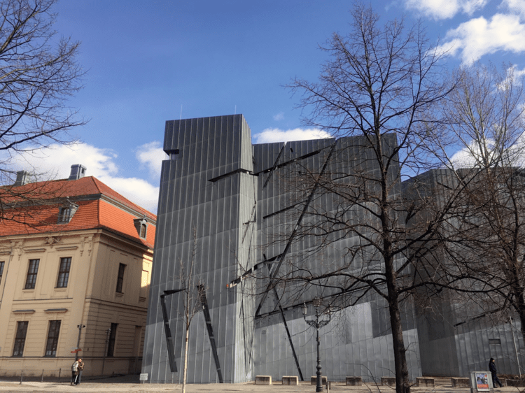 The Jewish museum - a gray zinc building with skinny diagonal cuts that let in light to the interior. This building is next to a traditional, stone and hip roof building - the original museum